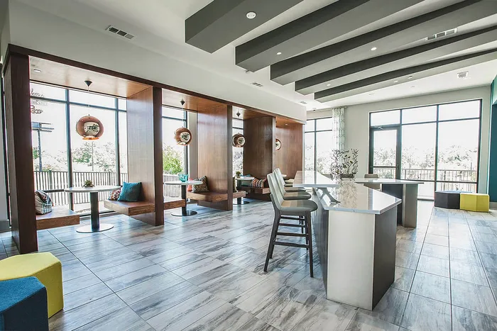 Modern common area with cozy booth seating, elegant lighting, and large windows creating a bright, inviting atmosphere.