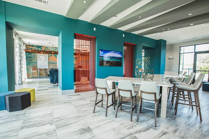Chic, modern open-concept apartment featuring stylish blue accent walls, elegant dining area, and ample natural light.