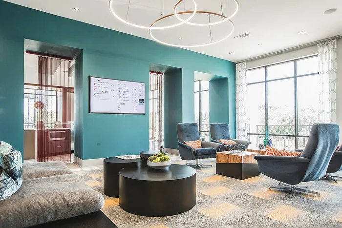 Modern living room featuring stylish blue accent wall, plush seating, and sleek lighting fixtures, designed for relaxation and comfort.