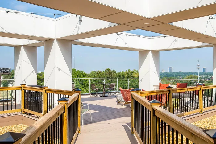 Elegant rooftop terrace with modern seating and lush green views, perfect for relaxing and entertaining.