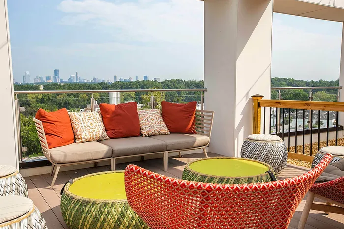 Chic rooftop terrace with cozy seating and vibrant furniture, offering stunning city skyline views.