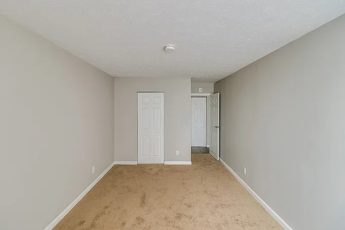 Bright and airy bedroom featuring soft beige carpet and neutral walls, perfect for cozy living.