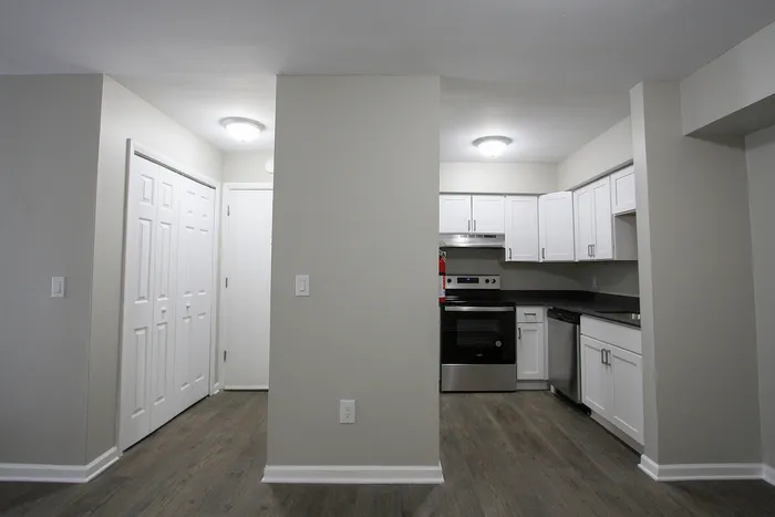 Modern kitchen with sleek white cabinetry, stainless steel appliances, and elegant wood flooring, perfect for culinary enthusiasts.
