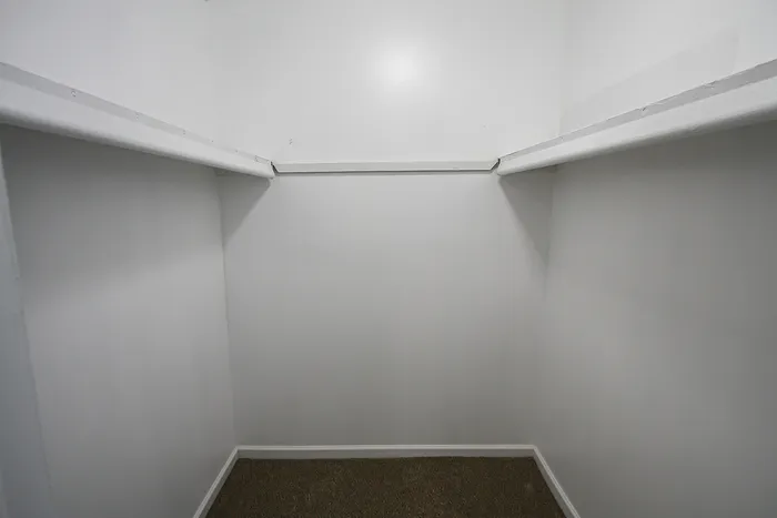 Spacious walk-in closet with ample shelving and clean, modern design.