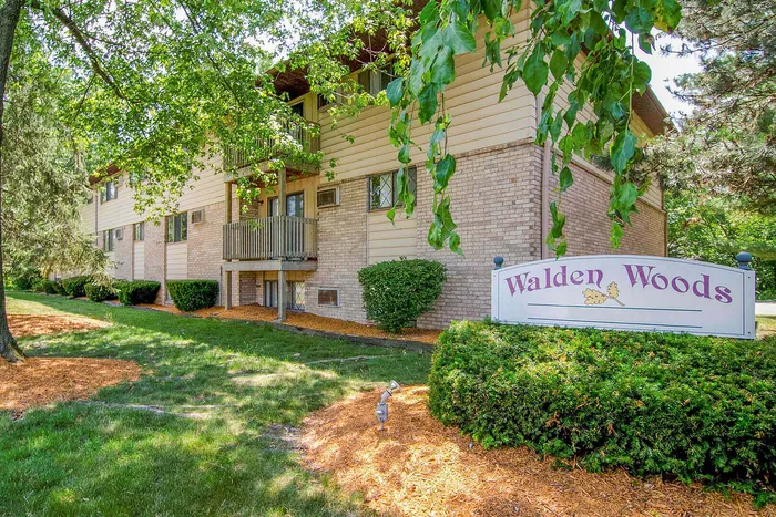 Charming apartment complex at Walden Woods, surrounded by lush greenery and well-maintained landscaping.