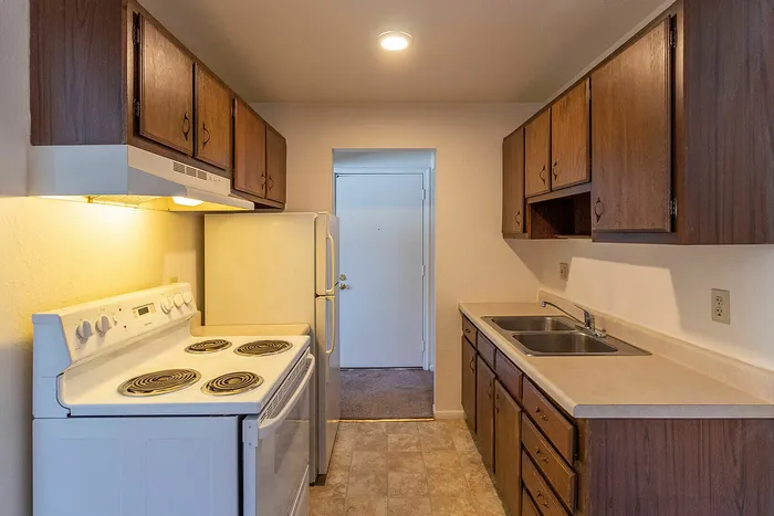Cozy kitchen with rich wood cabinetry, modern appliances, and warm lighting, perfect for culinary adventures.
