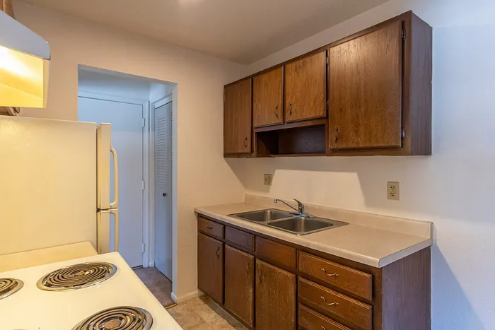 Cozy kitchen with elegant wooden cabinetry, sleek countertops, and modern appliances, offering a warm and inviting cooking space.