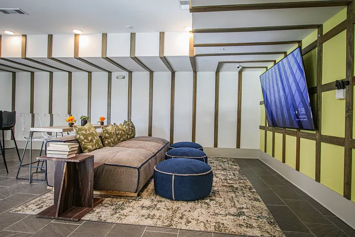 Chic living room with contemporary decor, featuring stylish seating, bold wall designs, and a wall-mounted TV for the ultimate entertainment experience.