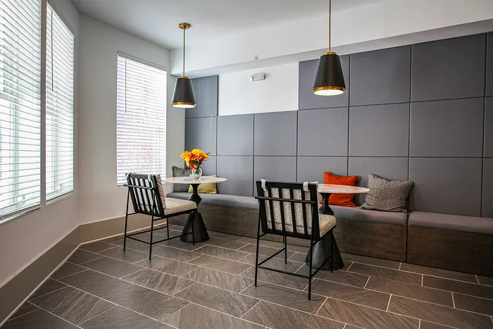 Elegant dining nook with modern decor, featuring plush seating, chic pendant lighting, and a cozy table setting.