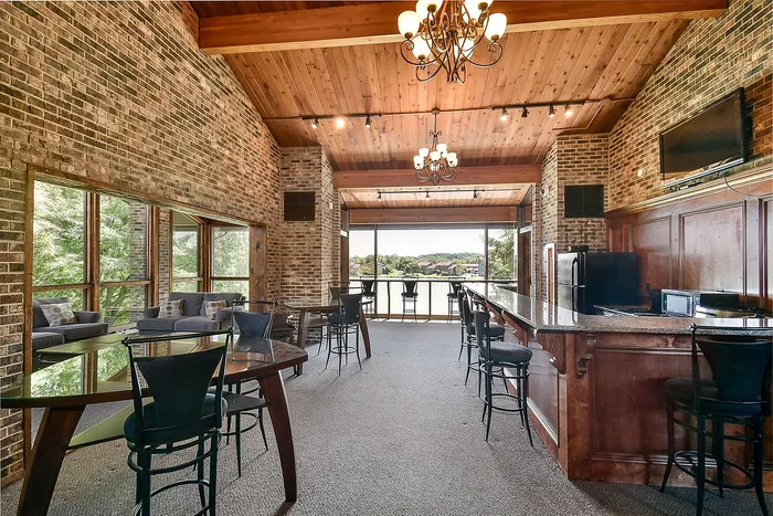 Charming rustic dining area with exposed brick walls, vaulted wooden ceiling, and large windows offering scenic views.
