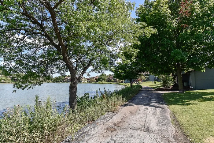 Scenic lakeside path surrounded by lush greenery, perfect for peaceful strolls and nature admiration.