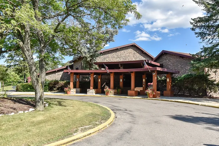Charming brick building with welcoming entrance, surrounded by lush greenery and pristine landscape.