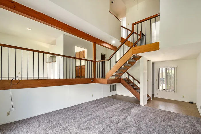 Charming split-level living space featuring modern staircase, wooden accents, and natural lighting.