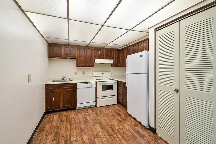Inviting kitchen with rich wooden cabinets, modern appliances, and elegant wood flooring creating a warm and functional space.