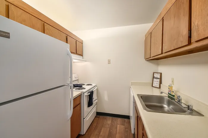 Cozy kitchen with modern appliances, wood cabinetry, and sleek countertops offering ample cooking space.
