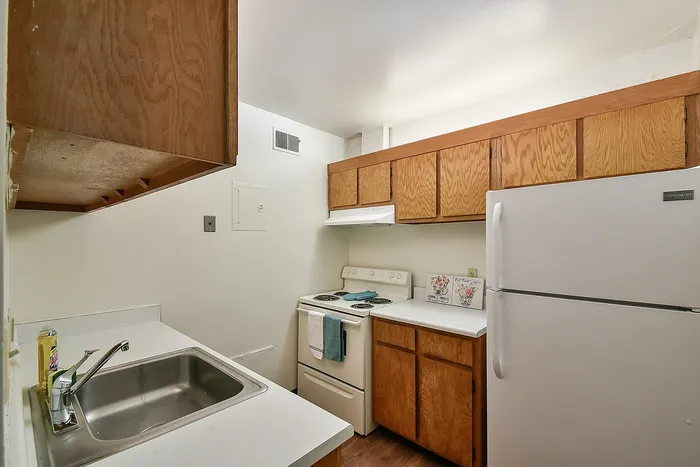 Charming kitchen with wooden cabinets, modern appliances, and a sleek sink, ideal for culinary adventures.