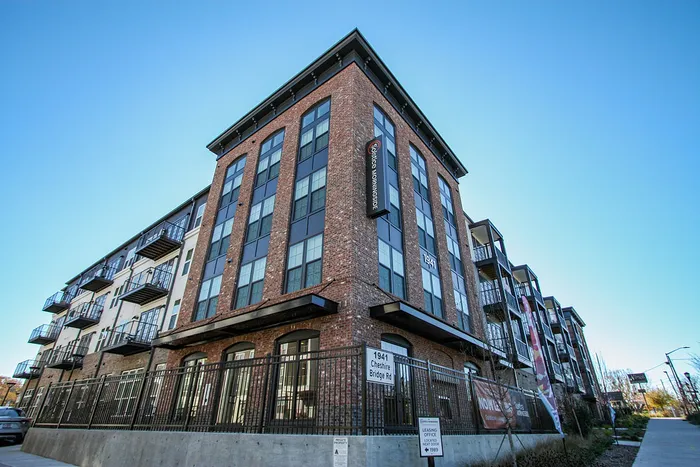 Modern apartment building with stylish brick facade and multiple balconies offering urban living in a vibrant neighborhood.