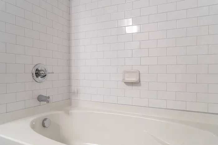 Elegant bathroom with a pristine white subway tile backsplash and a spacious bathtub.
