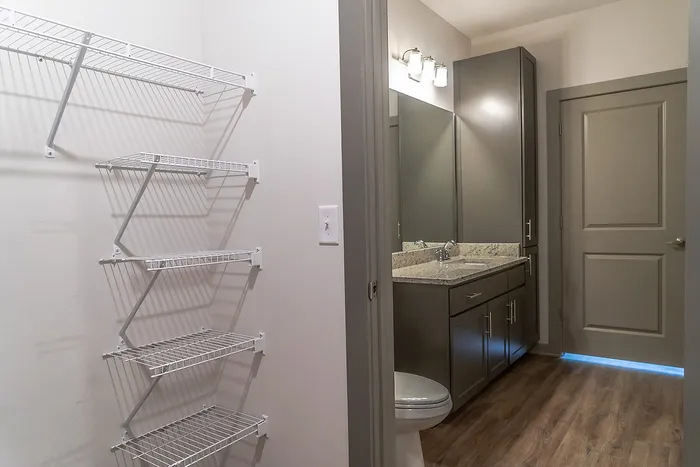 Chic bathroom with granite countertop, elegant storage cabinets, and ample shelving maximizing space and style.