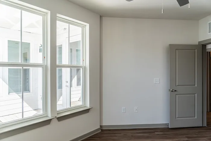 Bright and inviting room with large windows, promising abundant natural light and a serene atmosphere.