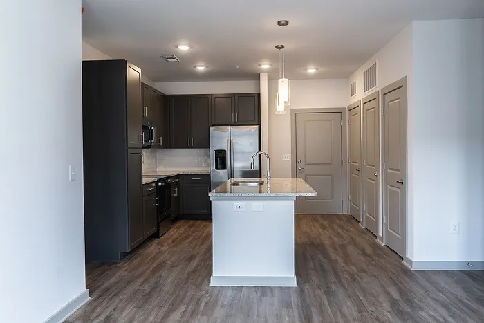 Elegant modern kitchen with sleek cabinetry, a center island, and stainless steel appliances, perfect for culinary enthusiasts.
