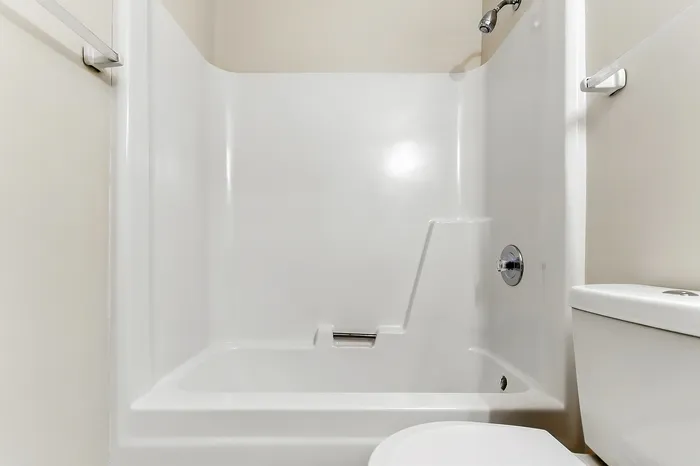 Bright, modern bathroom featuring a sleek white bathtub and contemporary fixtures.