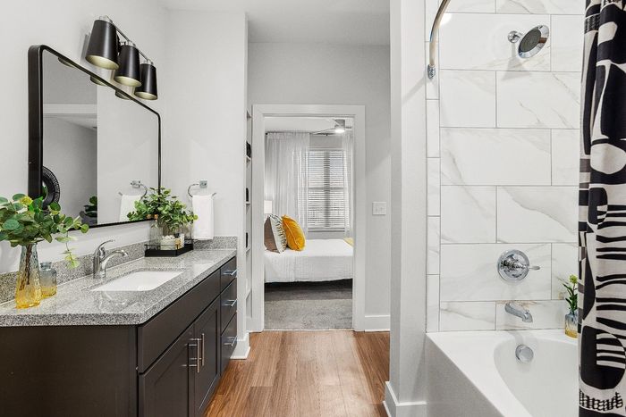 Luxurious bathroom with stylish vanity, elegant fixtures, and a glimpse into a cozy, well-lit bedroom.