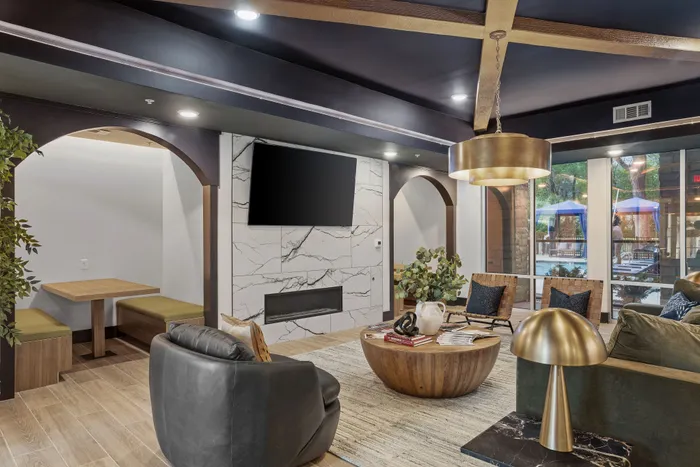 Chic modern living room with stylish seating, warm wooden flooring, elegant lighting, and a cozy dining nook.