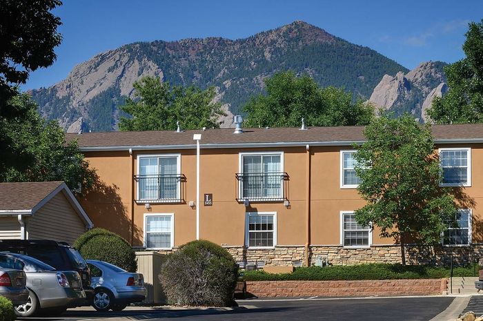Charming apartment building with picturesque mountain views and lush greenery, offering tranquility and natural beauty.