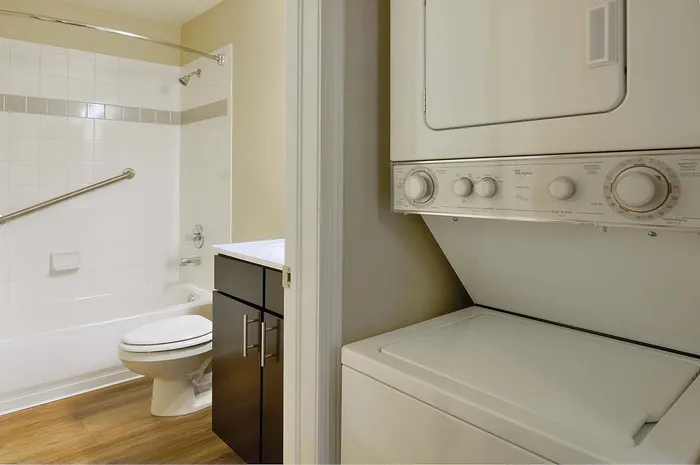 Modern bathroom with sleek vanity and convenient in-unit washer and dryer.