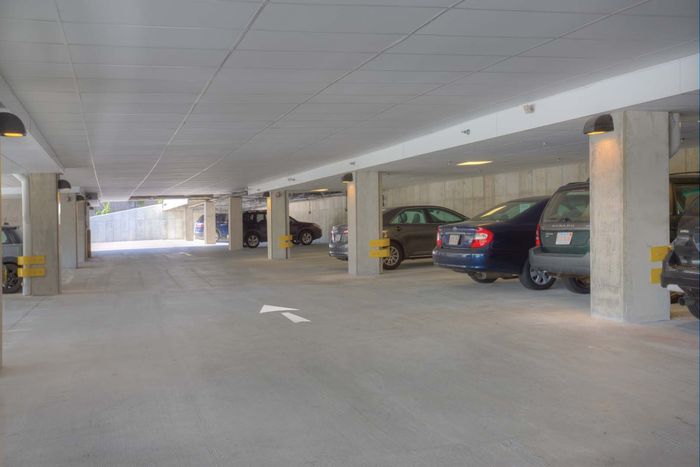 Spacious covered parking garage with ample light and secure parking spots, ideal for residents seeking convenience and safety.