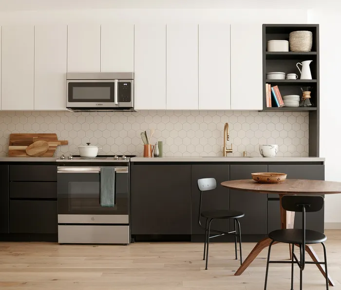 Modern kitchen with sleek cabinetry, stainless steel appliances, and a cozy dining area, ideal for stylish living.
