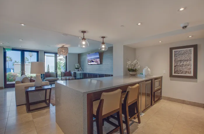 Luxurious open-plan community space boasting modern decor, an elegant chandelier, and scenic views through expansive windows.