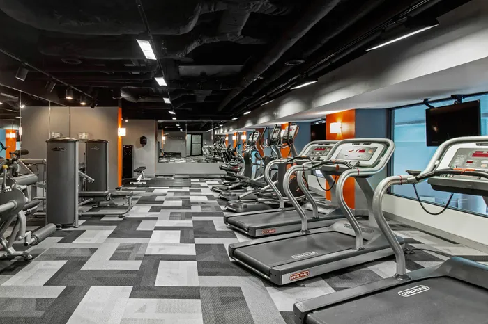 Modern gym equipped with state-of-the-art treadmills, exercise machines, and vibrant design for an energetic workout experience.