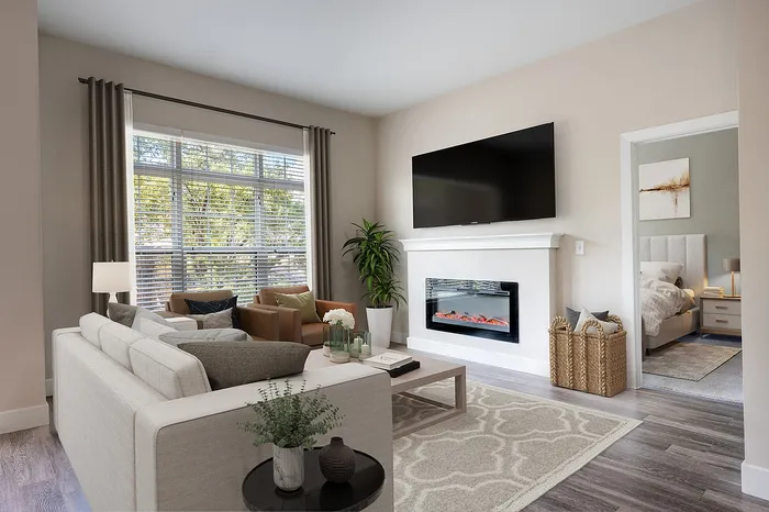 Inviting living room with cozy fireplace, large windows, modern furniture, and a glimpse into the elegant bedroom featuring soft lighting.