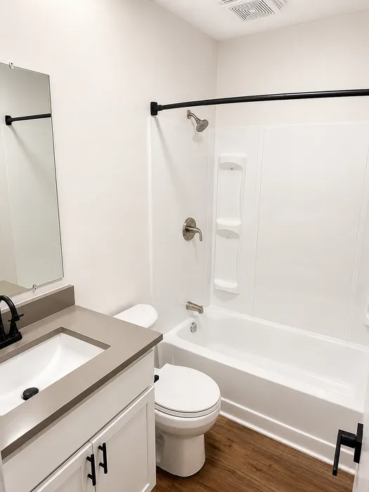 Elegant bathroom featuring a modern vanity, sleek countertop, and a pristine bathtub with contemporary fixtures.