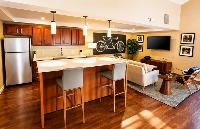 Inviting open-concept kitchen and living room with warm wood floors, modern decor, and cozy seating area.