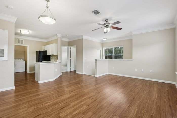 Charming open-concept apartment featuring elegant wood flooring, a modern kitchen, and ample natural light.