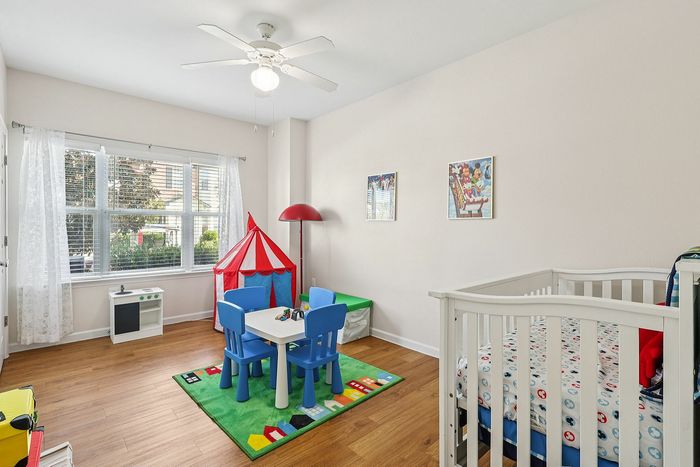 Charming children's room with vibrant decor, featuring a play area with colorful chairs, a small tent, and a cozy crib.