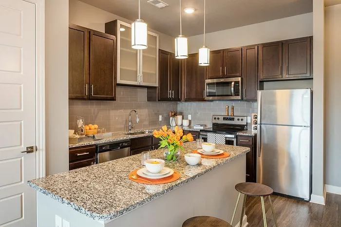 Modern kitchen with stainless steel appliances, sleek granite countertops, and stylish cabinetry, offering a chic and functional cooking space.