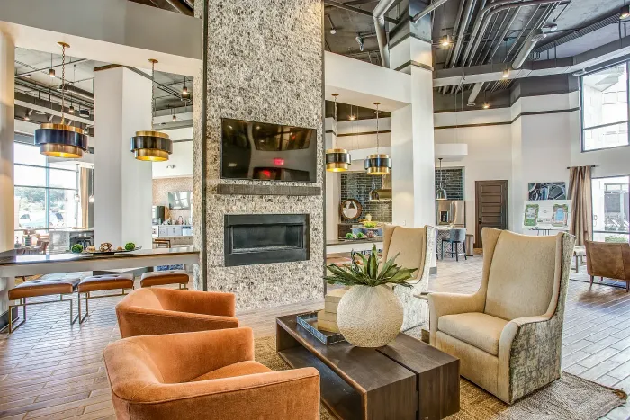 Modern open clubhouse featuring seating and fireplace