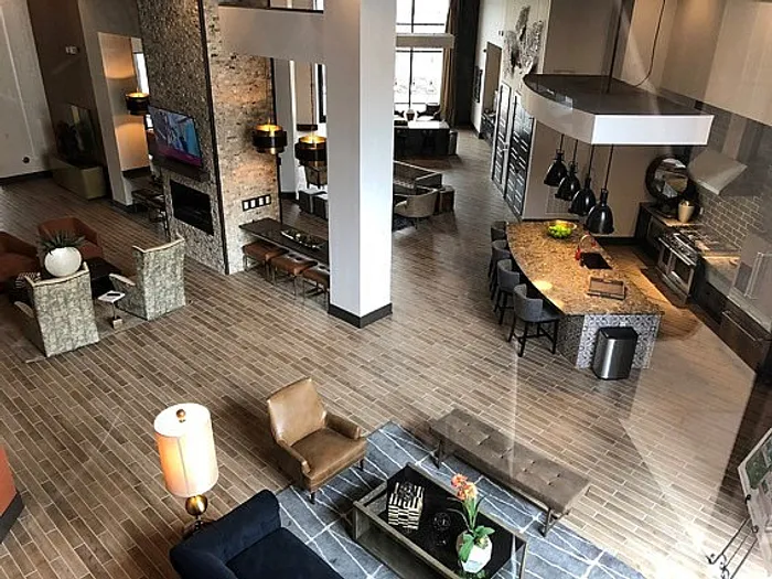 Luxurious open-concept living space with modern kitchen, stylish lounge area, and high ceilings, perfect for sophisticated apartment living.