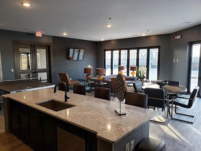 Modern apartment interior with elegant open-concept living area, stylish kitchen island, and chic dining space filled with natural light.