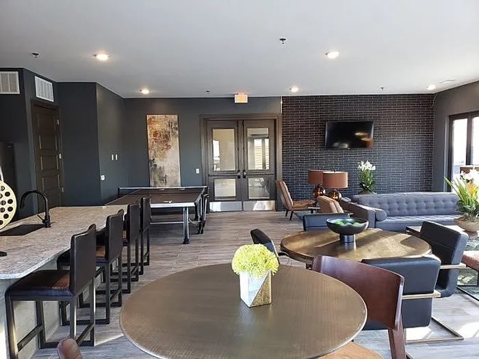Chic communal lounge featuring a modern design with a ping pong table, stylish seating, and elegant decor for social relaxation.