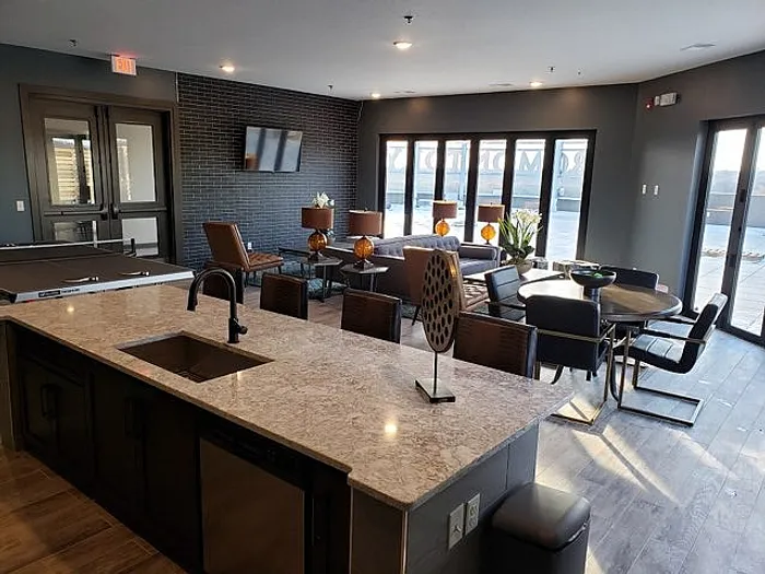 Modern apartment lounge with elegant decor, featuring a spacious open-concept layout, chic kitchen island, and stylish seating area.