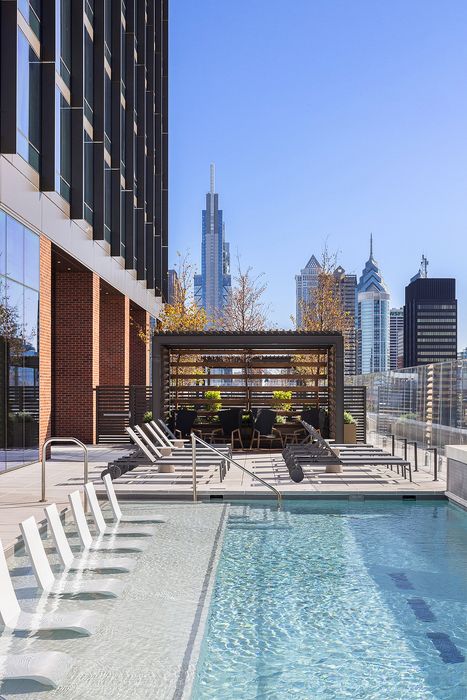 Luxurious rooftop pool with chic lounge chairs and stunning city skyline views.