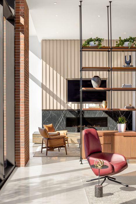 Luxurious apartment living room featuring contemporary design with plush seating, stylish shelving, and a modern fireplace with elegant stone accents.
