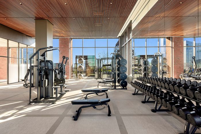 Luxurious state-of-the-art fitness center with panoramic city views, modern equipment, and spacious design.