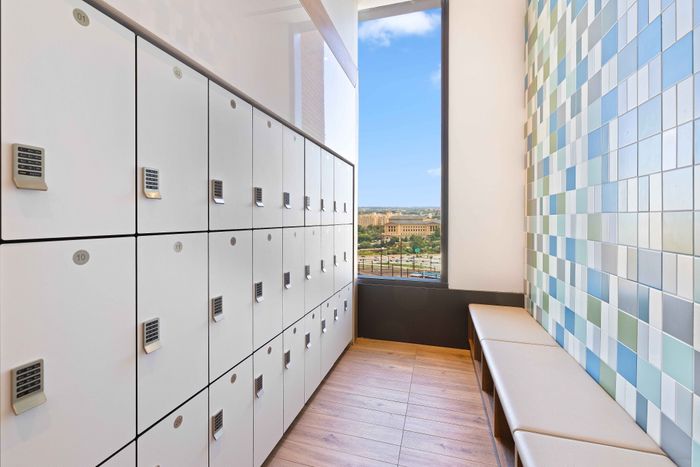 Modern locker room with secure storage, vibrant tiled walls, and scenic window view enhancing the space.