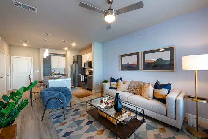 Contemporary open-concept living room with stylish furniture, vibrant decor, and a modern kitchen island, ideal for urban living.